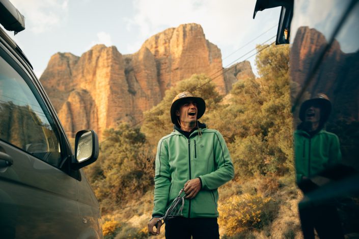 escalador riendose mientras prepara el material de escalada en Riglos