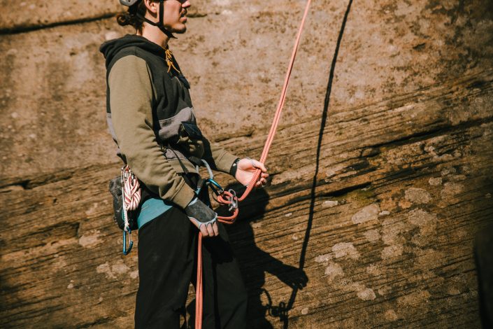 escalador asegurando en Stanage Peak District