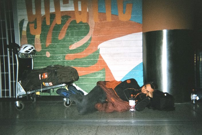foto analogica de escalador durmiendo en el aeropuerto