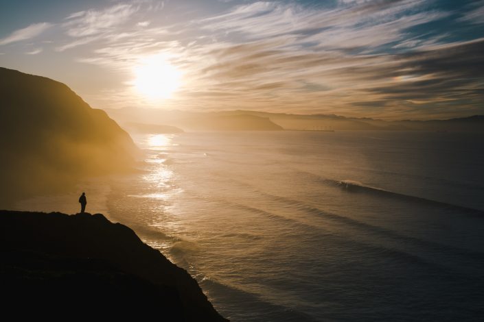 una persona observando el atardecer y las olas en Barrika